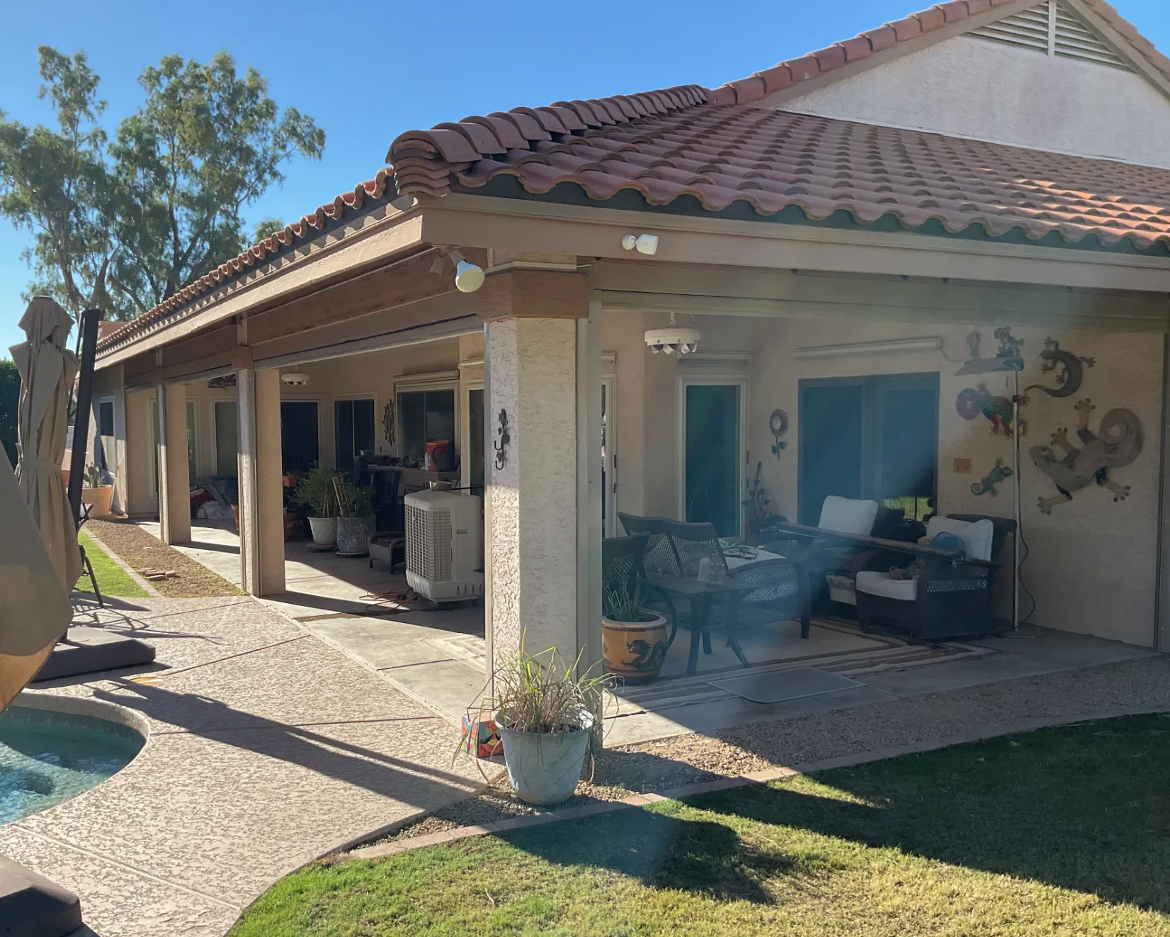 Outdoor shade system covering a patio, helping protect furniture from sun damage