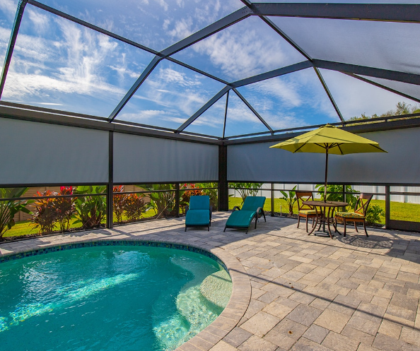 Pool enclosure with screens reducing heat and humidity for improved outdoor comfort