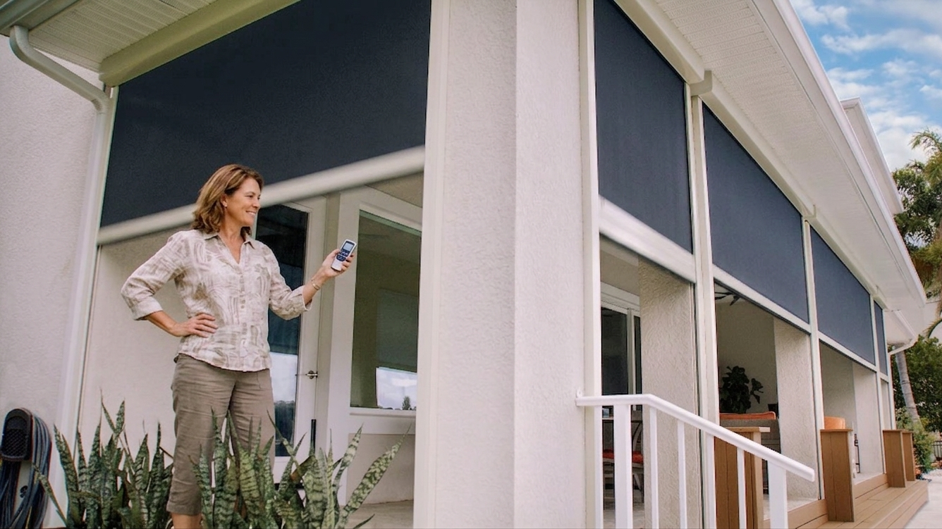 Woman using a handheld remote to lower motorized patio